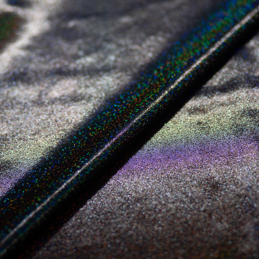 Close-up of a black textured surface with a multicolored sheen